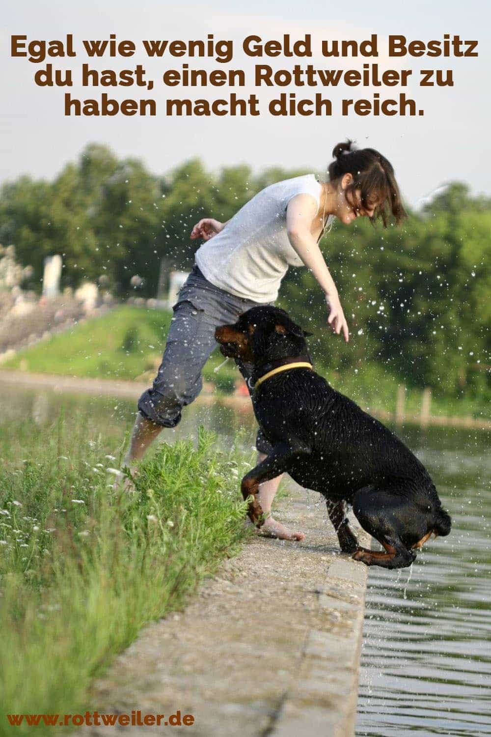 Junge Frau spielt mit Rottweiler Hund am Wasser